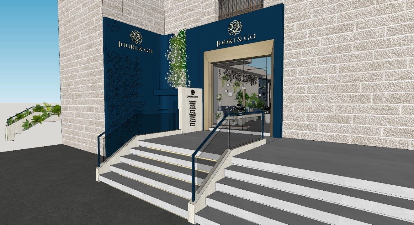 Joori & Go storefront: navy façade with gold rose logos, a gold-framed glass entrance and stone steps